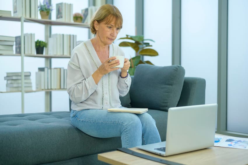 Reinventing Yourself - Photo of a Middle-Aged Woman with a laptop and cup of coffee